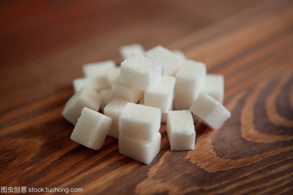 棕色木桌上的白糖立方体